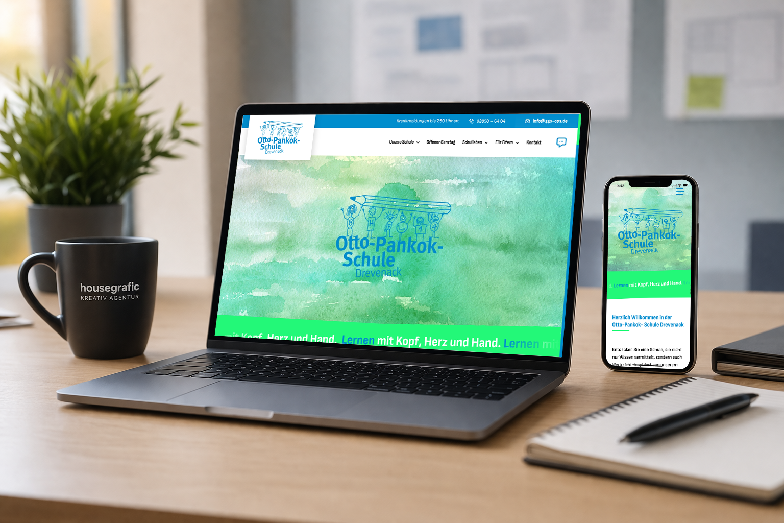 blog_neue_homepage_ottopankokschuledrevenack Modernes Arbeitsumfeld mit Laptop und Smartphone, auf denen die neue Website der Otto-Pankok-Schule Drevenack responsiv dargestellt wird; klar strukturiertes Design auf einem aufgeräumten Schreibtisch mit Notizbuch und Kaffeetasse.